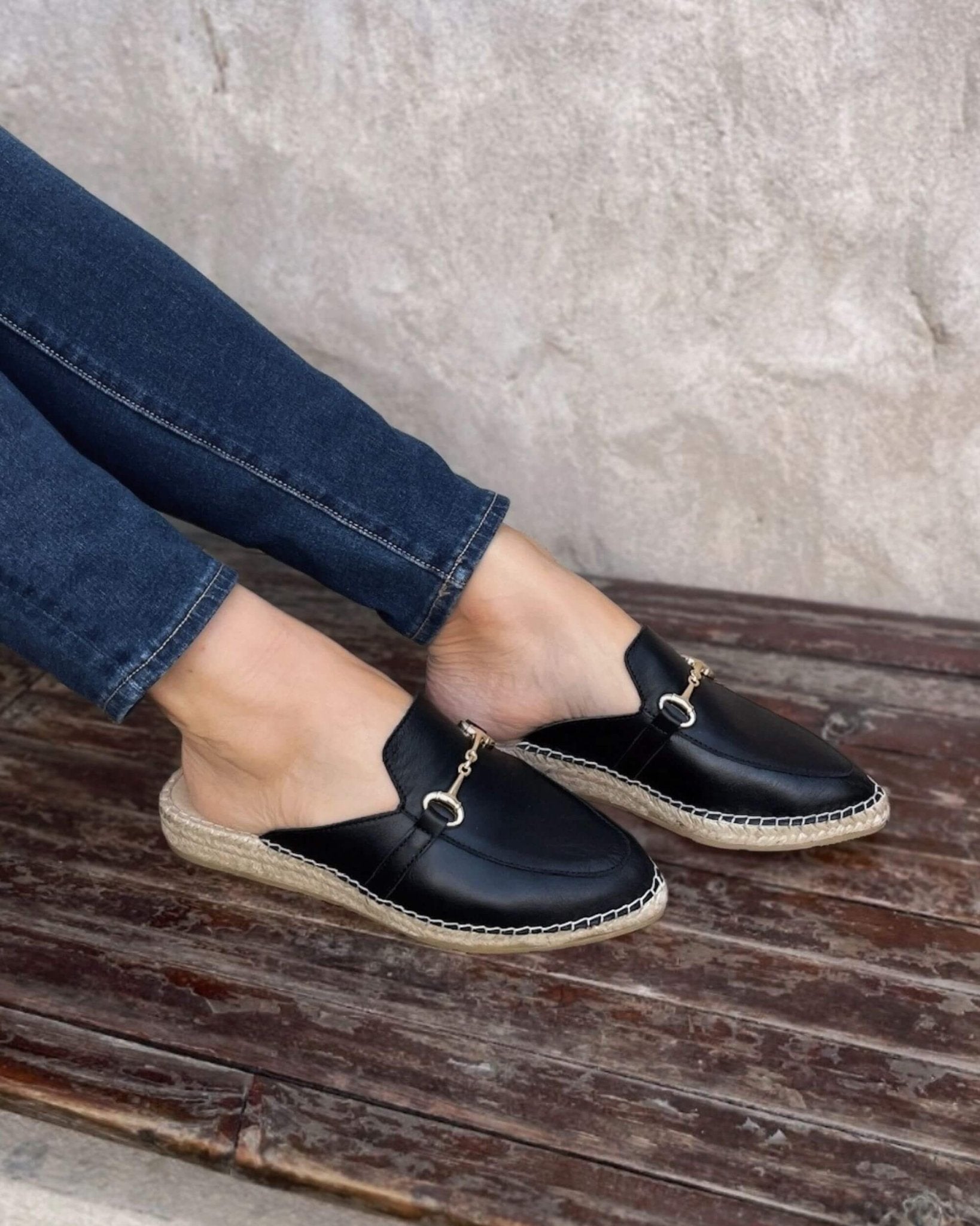 Black leather closed-toe mules back view jute base
