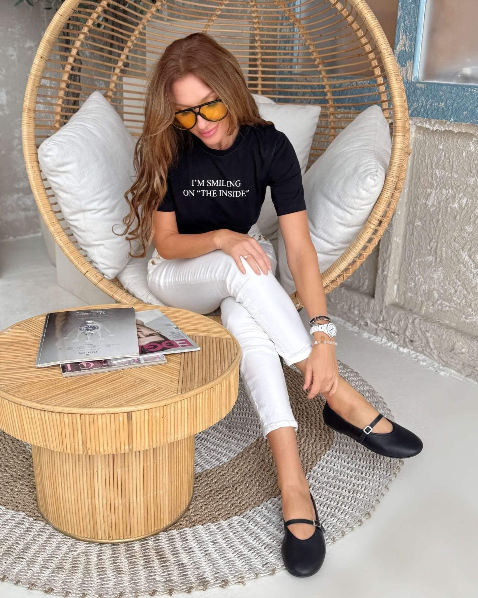 Handmade black nappa leather Mary Jane flats with ankle strap worn seated in rattan chair, styled with white jeans | Mary Jane in Midnight by Shoeq