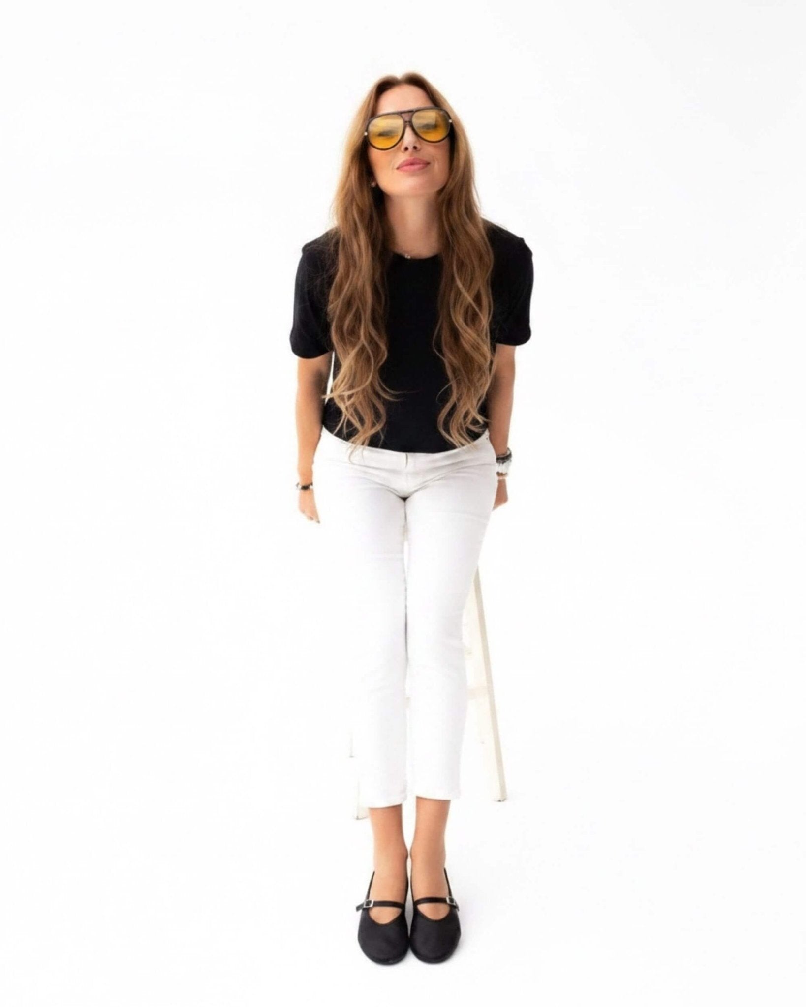 Handmade black nappa leather Mary Jane flats with ankle strap styled with white trousers and black top — standing lifestyle | Mary Jane in Midnight by Shoeq